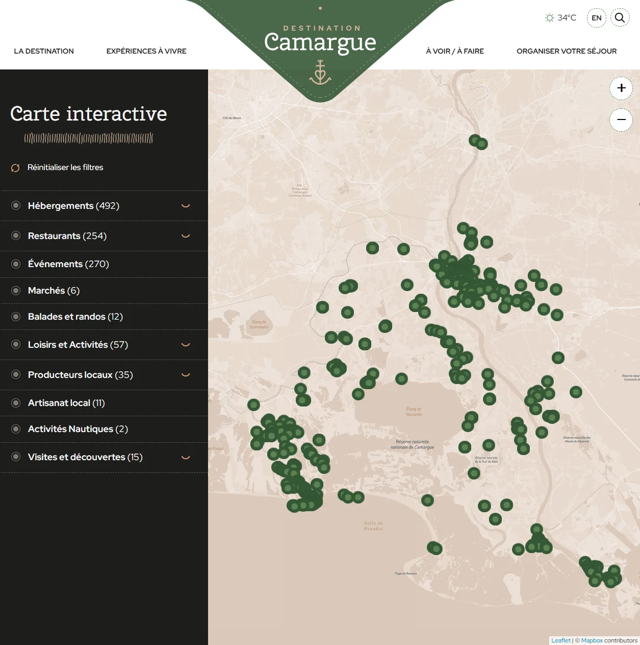 Carte interactive plein écran avec menu de catégories à gauche (hébergements, restaurants, événements, marchés...) et marqueurs groupés par zone sur la carte